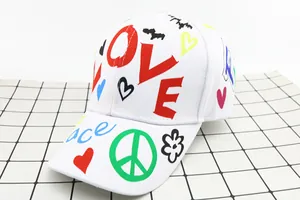 Dettaglio del berretto bianco con stampa LOVE graffiti e simbolo della pace sulla visiera
