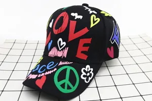 Dettaglio di un cappello da baseball nero per bambini con stampe graffiti LOVE e Peace