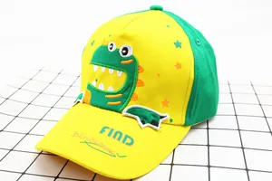 Close-up of kids yellow baseball cap with green dinosaur embroidery and cotton texture
