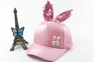 Detail of pink girls baseball cap featuring sequined rabbit ears and pearl butterfly decor
