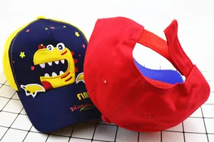 Detail view showing cartoon dinosaur embroidery and adjustable velcro strap of the kids cap