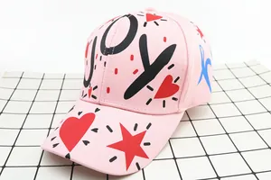 Dettaglio del berretto da baseball rosa in cotone con graffiti JOY e cuori rossi