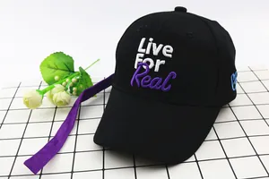 Detail of black baseball cap with purple ribbon and Live For Real 3D embroidery