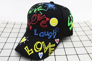 Dettaglio cappello nero in cotone con graffiti neon e stampa LOVE multicolore