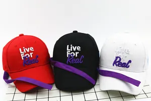 Close-up of kids baseball caps with Live For Real embroidery and purple ribbon detail