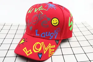 Dettaglio del cappellino rosso per bambini con stampe graffiti LOVE e LAUGH
