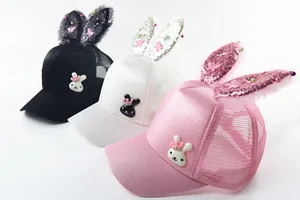 Close-up of girls' sun hats with sequin rabbit ears and pearl bow detail in three colors
