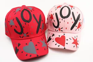 Vista dall'alto di cappellini in cotone rosso e rosa con graffiti LOVE e stelle