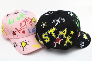 Dettaglio di cappellini da baseball rosa e neri con graffiti colorati e stampe di testo