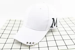 Détail de la casquette blanche en coton avec broderie M noire et trois anneaux métalliques