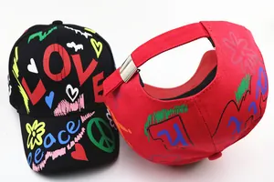 Dettaglio del cappellino bimbo con fibbia in metallo argento e stampa graffiti colorata