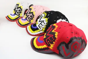 Vista piatta di quattro cappellini da baseball in cotone con graffiti LOVE colorati