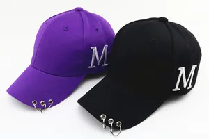 Détails des casquettes violettes et noires avec anneaux argentés et broderie M