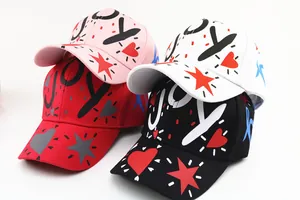 Dettaglio dei cappellini da baseball in cotone per bambini con scritte LOVE e stelle
