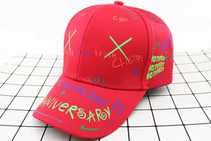 Detail shot of a red kids' baseball cap featuring colorful graffiti and street dance patterns