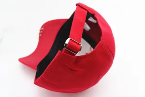 Détail de la casquette rouge avec trois anneaux argentés et boucle en métal ajustable