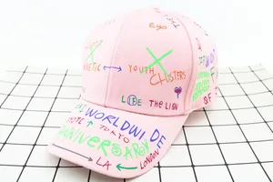 Detailed view of pink kids baseball cap featuring colorful street graffiti and slogans