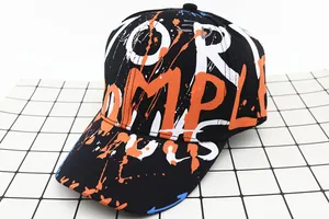 Detail of black baseball cap with vibrant street graffiti and colorful artistic prints