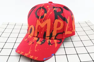 Detail of red kids baseball cap featuring graffiti style lettering and cotton twill fabric