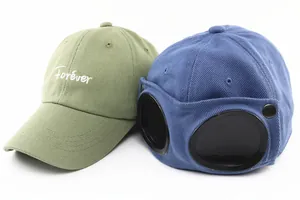 Detail of green 'Forever' embroidery and blue pilot baseball cap with goggles