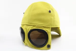 Close-up of yellow aviator baseball cap featuring integrated goggles and metal studs