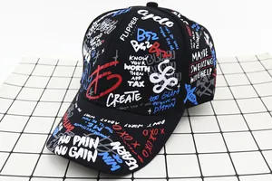 Detail of a black baseball cap with vibrant graffiti letters and street style print