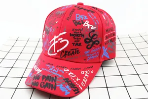 Detail of red kids baseball cap with graffiti print and streetwear slogan embroidery