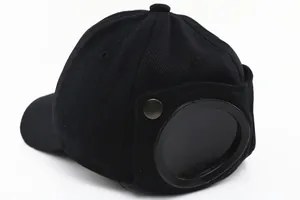 Detail of black aviator style baseball cap featuring built-in rear goggles and metal snaps