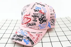 Detail view of pink cotton baseball cap with colorful graffiti print and street style text