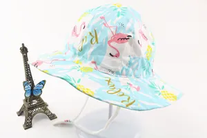 Detail of baby sun hat with flamingo and pineapple prints including windproof strap