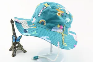 Detail of green kids sun hat with cartoon prints and adjustable white chin strap