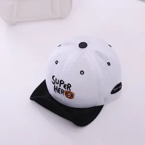 Détail de la maille blanche et de la broderie ours Super Hero sur une casquette pour enfant