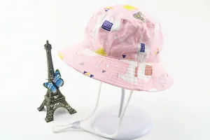 Detail of pink cotton sun hat featuring cartoon llama patterns and adjustable chin strap