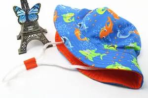 Close-up of kids sun hat with cartoon shark print, blue exterior and orange lining