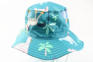 Close-up of green cotton kids sun hat with giraffe and zebra cartoon animal patterns