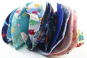 Close-up of children's cotton sun hats with colorful shark and dinosaur cartoon prints