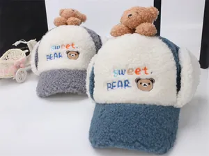 Dettaglio di cappelli con paraorecchie in peluche per bambini con ricamo a orsetto