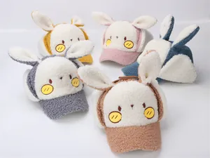 Row of colorful children's winter baseball caps with cute bunny ears in soft sherpa fleece