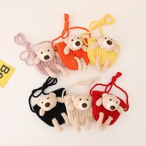 Detail view of colorful knitted crossbody bags featuring cute 3D plush teddy bear designs