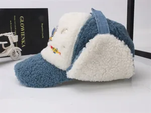 Détail du bonnet trappeur en polaire bleu et blanc avec broderie fusée pour enfant