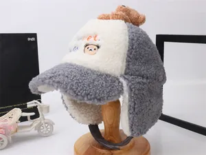 Dettaglio del cappello invernale per bambini con texture in pile e decorazione a orsetto