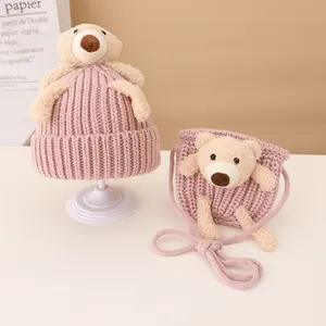 Close-up of knit baby hat and matching crossbody bag with cute teddy bear ornaments