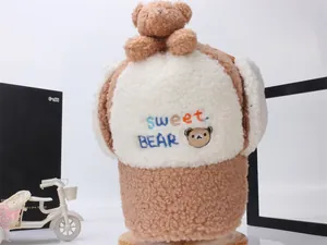 Dettaglio del cappello da aviatore in peluche per bambini con ricamo orso e fodera calda pile