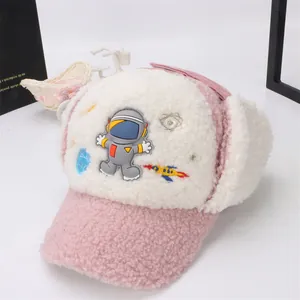 Détail du bonnet d'hiver rose en sherpa avec écusson astronaute et broderie fusée