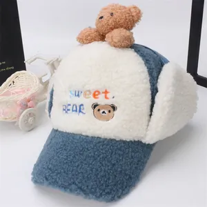 Dettaglio del cappello invernale per neonati con orsetto di peluche e ricamo
