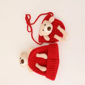 Close-up of red knit hat and matching bag set with cute plush bear decorations