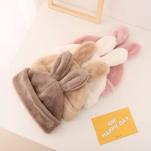Close-up of soft plush bunny ear hats in four warm colors with fluffy fleece lining