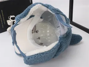 Detail view of winter hat with plush white lining and blue fleece ear flaps with velcro strap