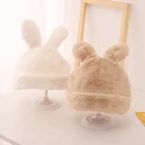 Close-up of fluffy animal-ear beanies with thick fleece lining in white and khaki
