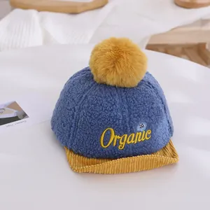 Détail du bonnet d'hiver pour bébé en polaire bleue avec pompon jaune et broderie